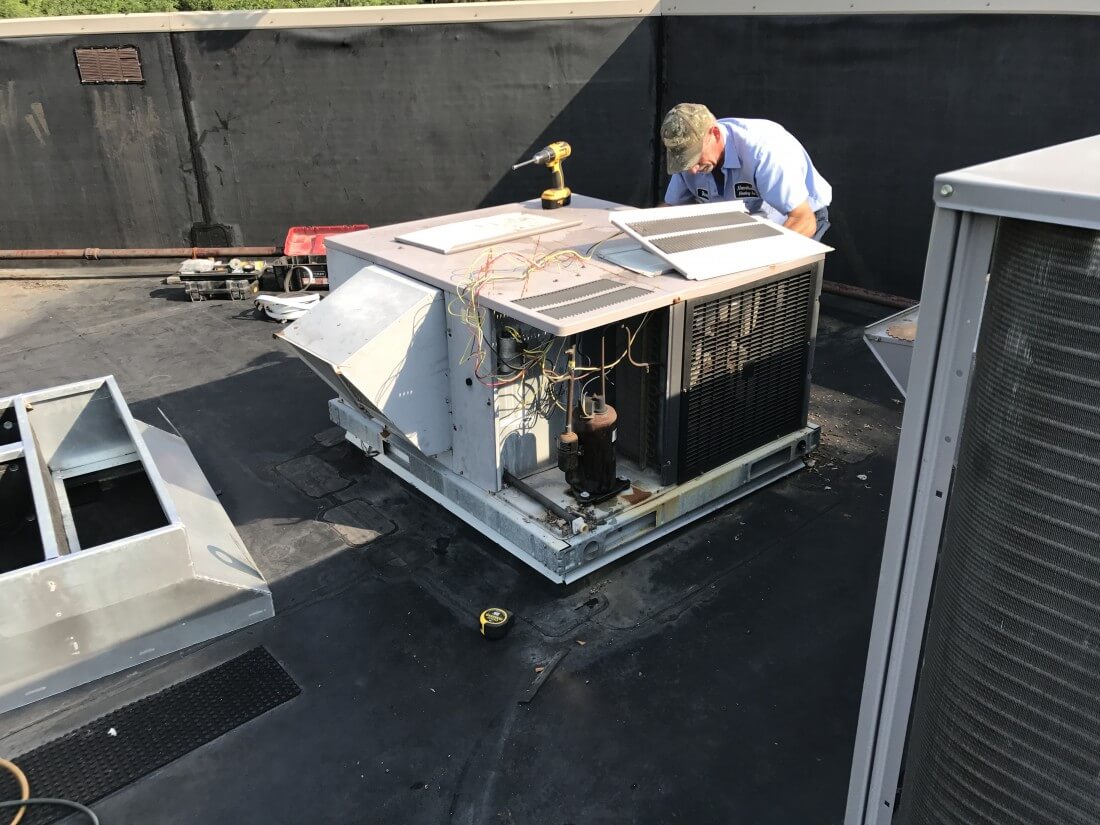 Picture of a man repairing a air conditioner 