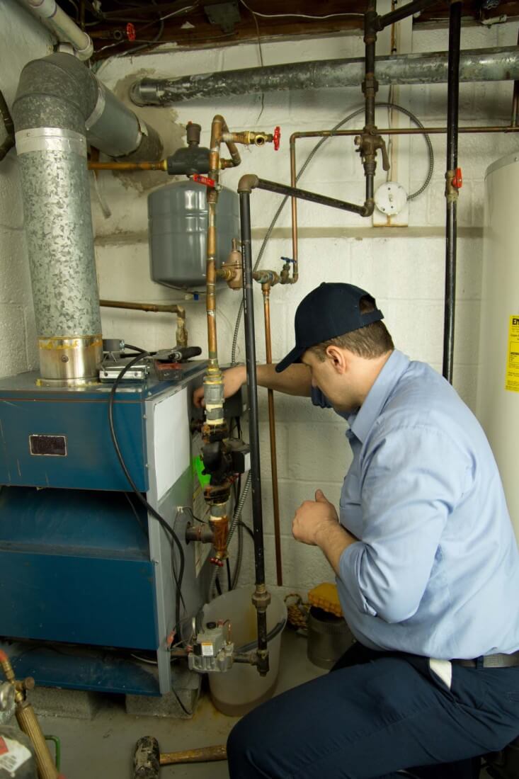 Picture of a man repairing a Prompt Heating System